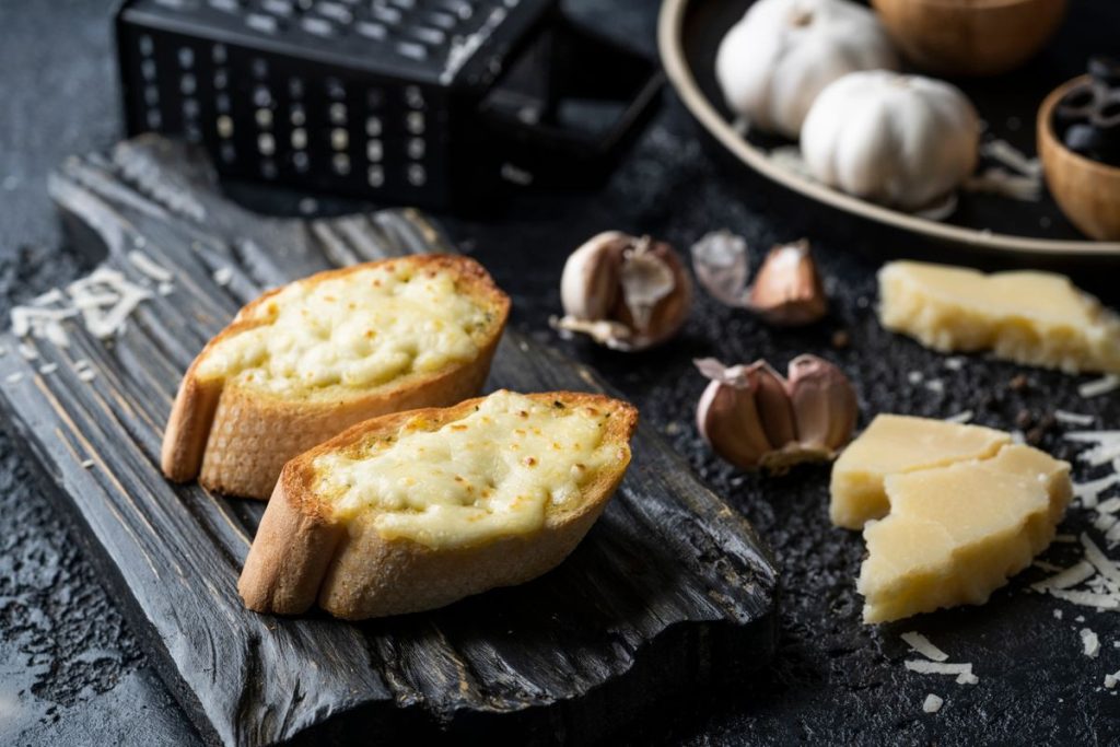 Bánh mì bơ tỏi phô mai nướng vàng trên thớt