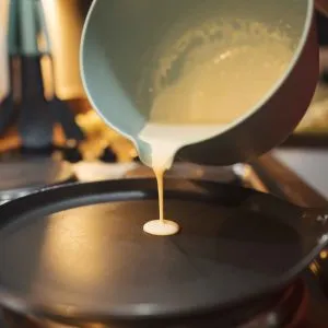 Đổ bột bánh kếp vào chảo chống dính đã làm nóng