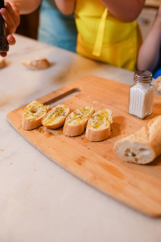 Cắt bánh mì baguette thành lát để làm bánh mì bơ tỏi